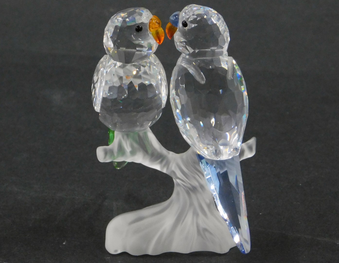 A Swarovski crystal figure group of two birds on perch, with coloured glass tails and beaks, 9cm hig