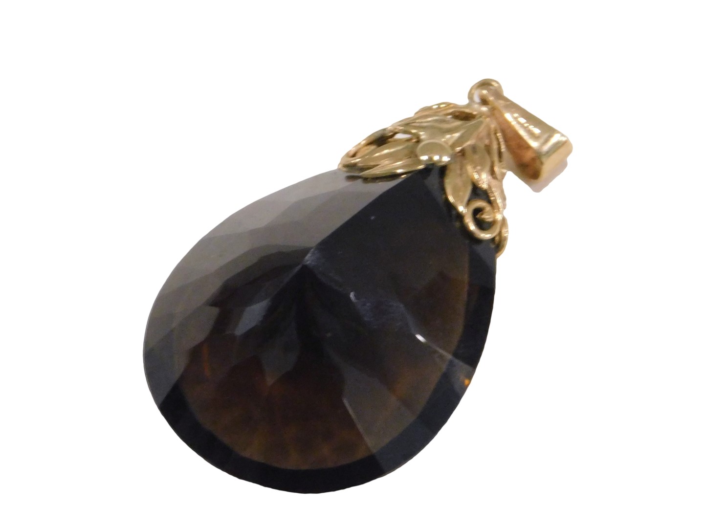 A smokey quartz pendant, the tear drop cut smokey quartz, 4cm high x 2.5cm wide, with a 9ct gold flo