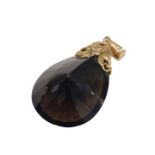 A smokey quartz pendant, the tear drop cut smokey quartz, 4cm high x 2.5cm wide, with a 9ct gold flo