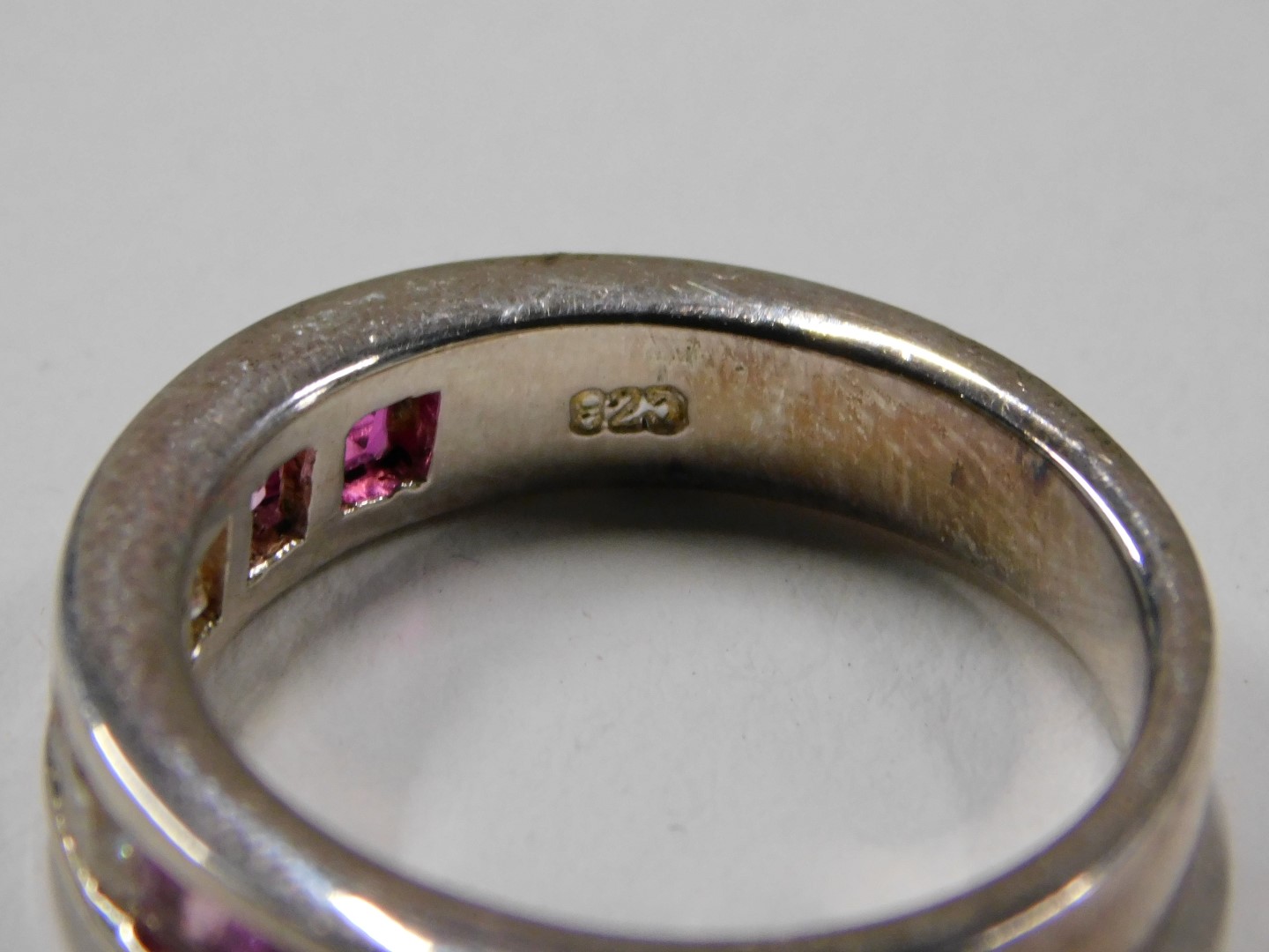 A dress ring, set with pink and white square set stones, channel set, on a white metal setting stamp - Image 4 of 4