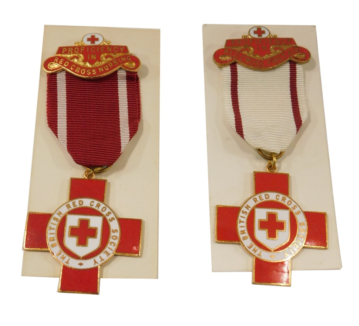 A British Red Cross Society enamel nurse's badge, and a first aid Red Cross badge, boxed. (2)