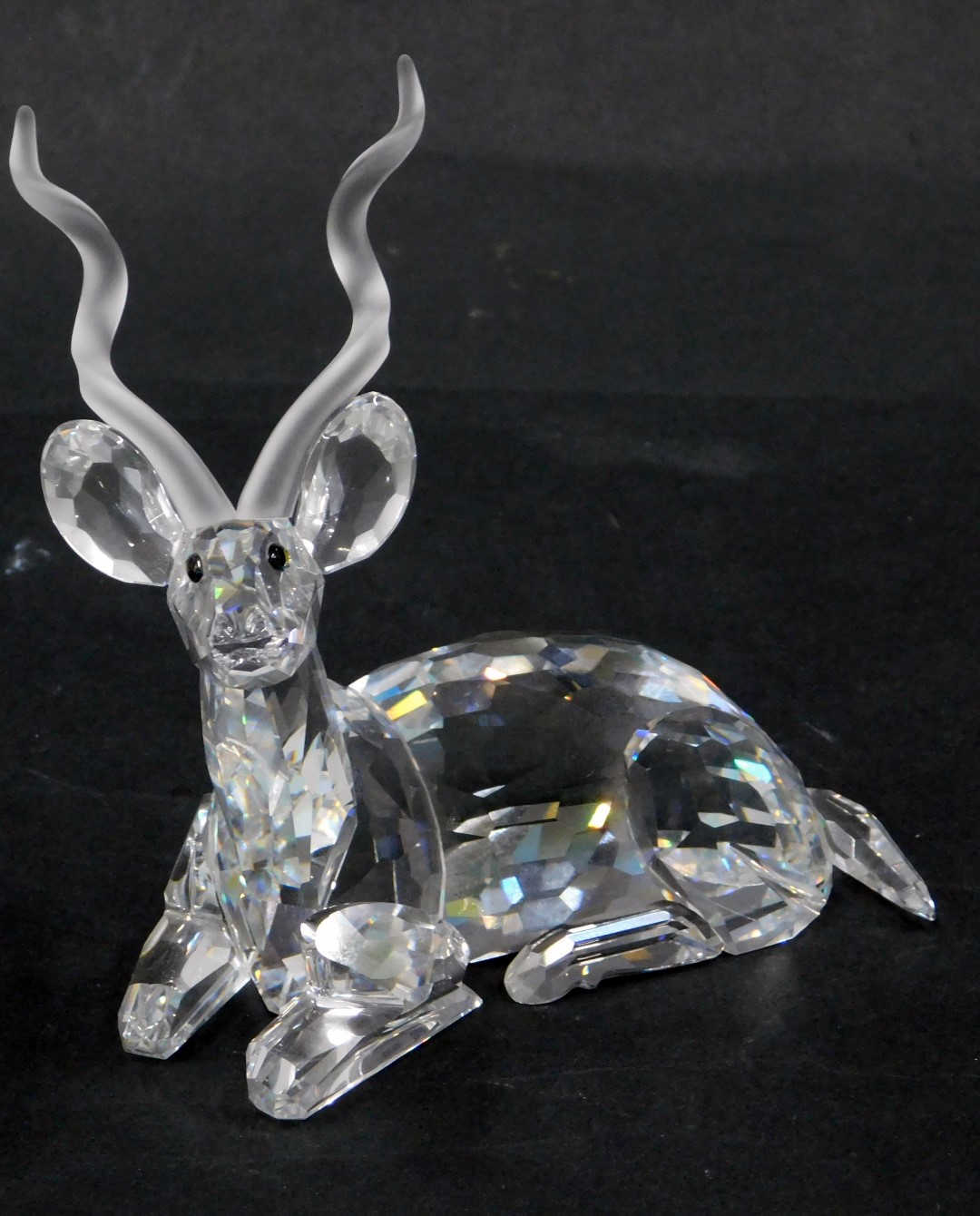 A Swarovski crystal seated antelope figure, with amber eyes, 10cm wide, boxed.