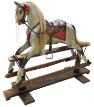 A dapple grey painted rocking horse, with leather saddle and bridle, etc., on an ash trestle base wi