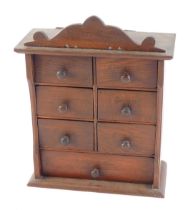 A late 19th/early 20thC oak spice cabinet, the drawers with indistinct stencil decoration and turned