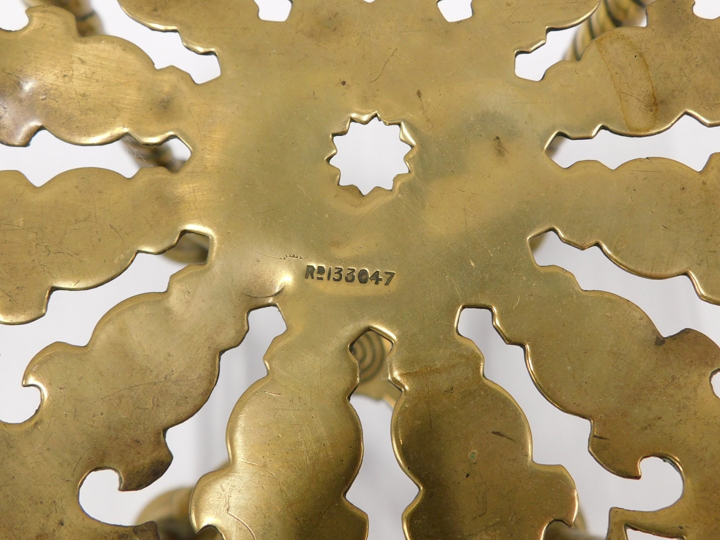 A 19thC brass and iron trivet, decorated with an eagle, two other trivets, and a Victorian range cli - Image 2 of 2