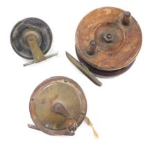 Three fishing reels, comprising a Nottingham style wooden reel, 7cm diameter, and two other reels, 6