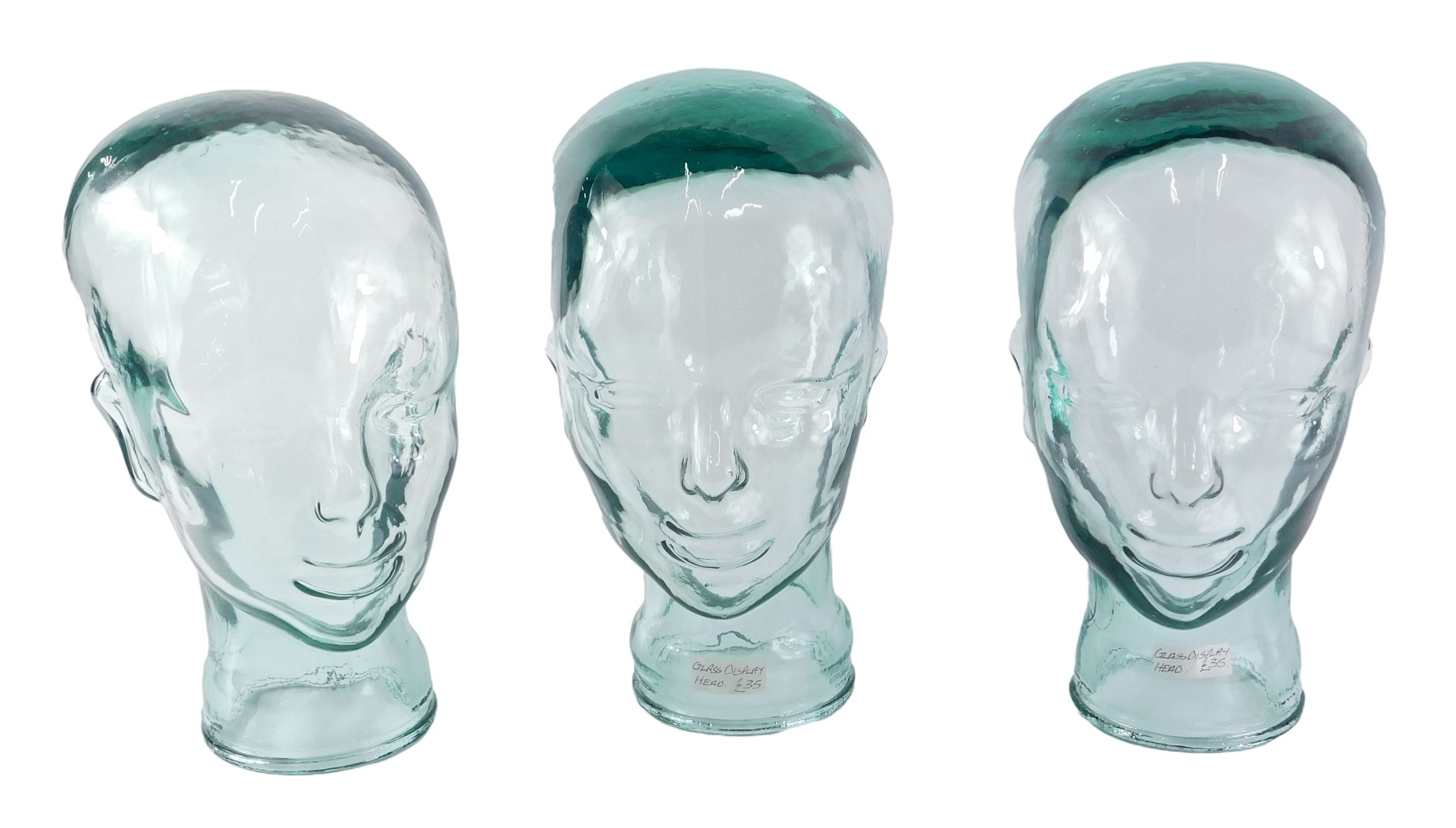 Three vintage glass shop display heads, 28cm high.