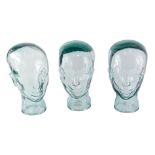 Three vintage glass shop display heads, 28cm high.