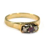 A 9ct gold three stone dress ring, set with garnet and diamonds, each in raised claw setting, on a p