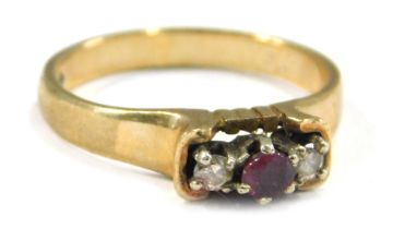 A 9ct gold three stone dress ring, set with garnet and diamonds, each in raised claw setting, on a p