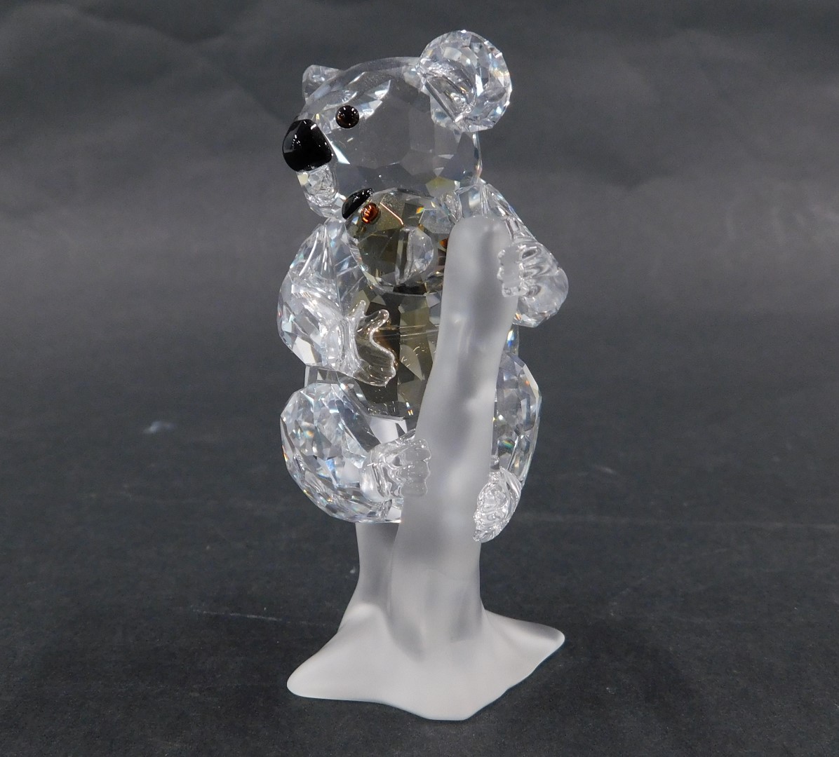 A Swarovski crystal figure group of two koala bears, mother and baby, perched on branch, with black - Image 2 of 3