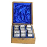 A cased set of napkin rings, comprising one silver napkin ring bearing the initials MJW, 0.50oz, and