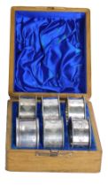 A cased set of napkin rings, comprising one silver napkin ring bearing the initials MJW, 0.50oz, and