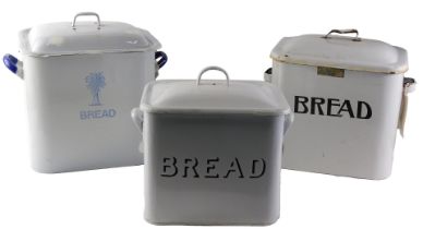 Three enamel bread bids, comprising a cream enamel bread bin and lid, 29cm high, a cream and blue en