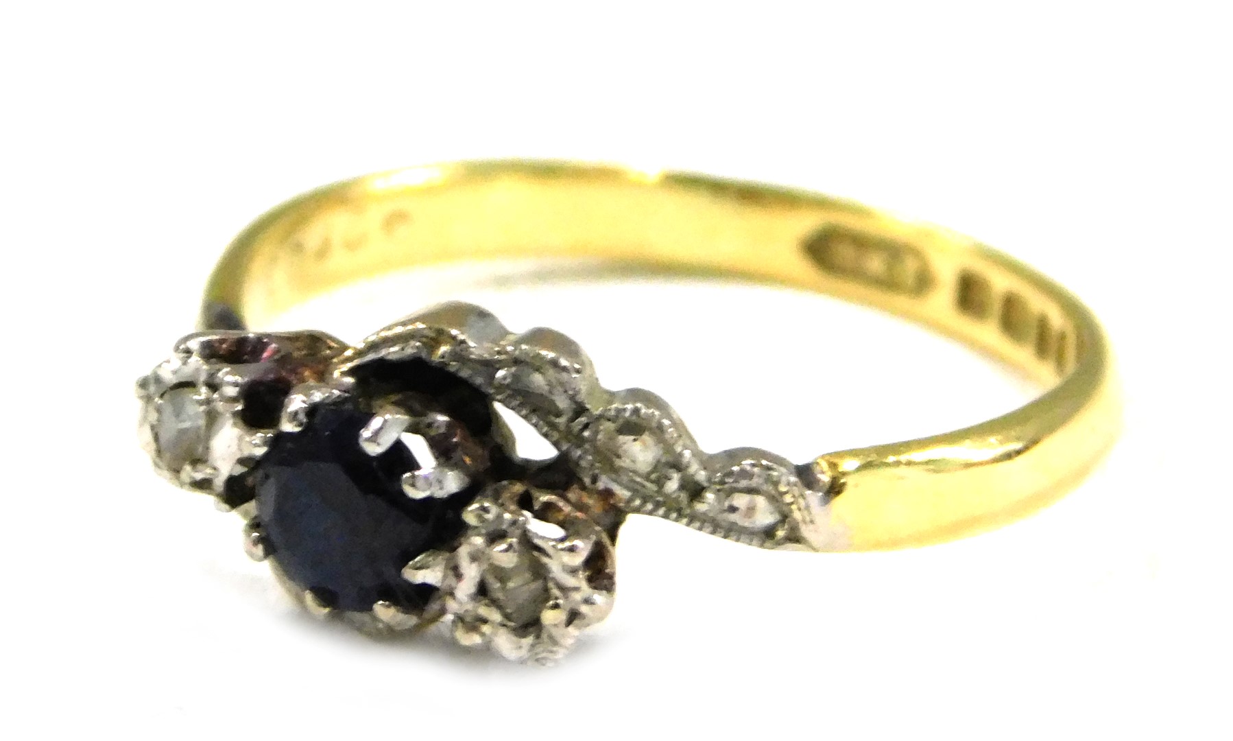 An 18ct gold sapphire and diamond dress ring, of twist design, set with oval cut sapphire and two il