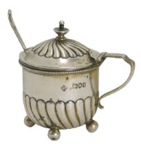 An Edward VII silver mustard, with fluted design, on four bun feet, with a silver preserve spoon