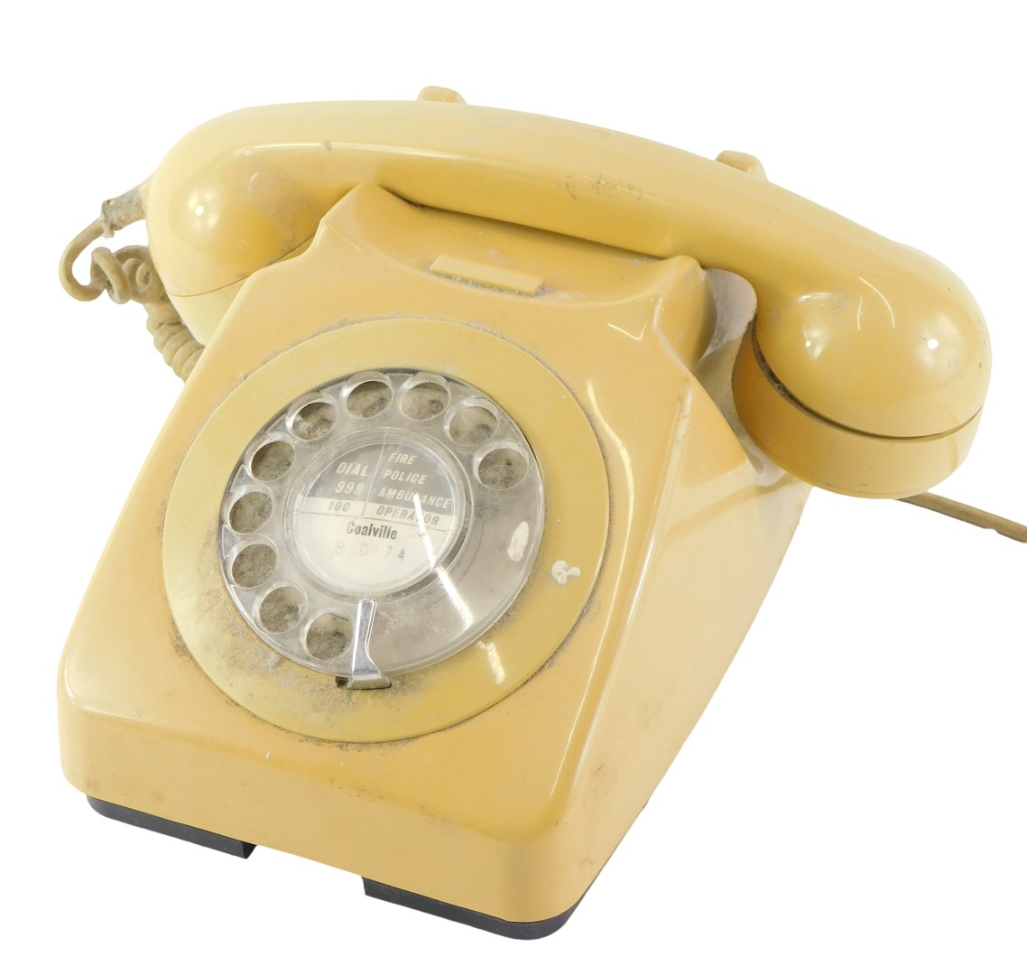 A mustard coloured vintage plastic telephone, stamped 746F, DFM, 80/2.