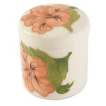 A Moorcroft lidded pot, cylindrical form, on a cream ground, with pink flowers, 9cm high.