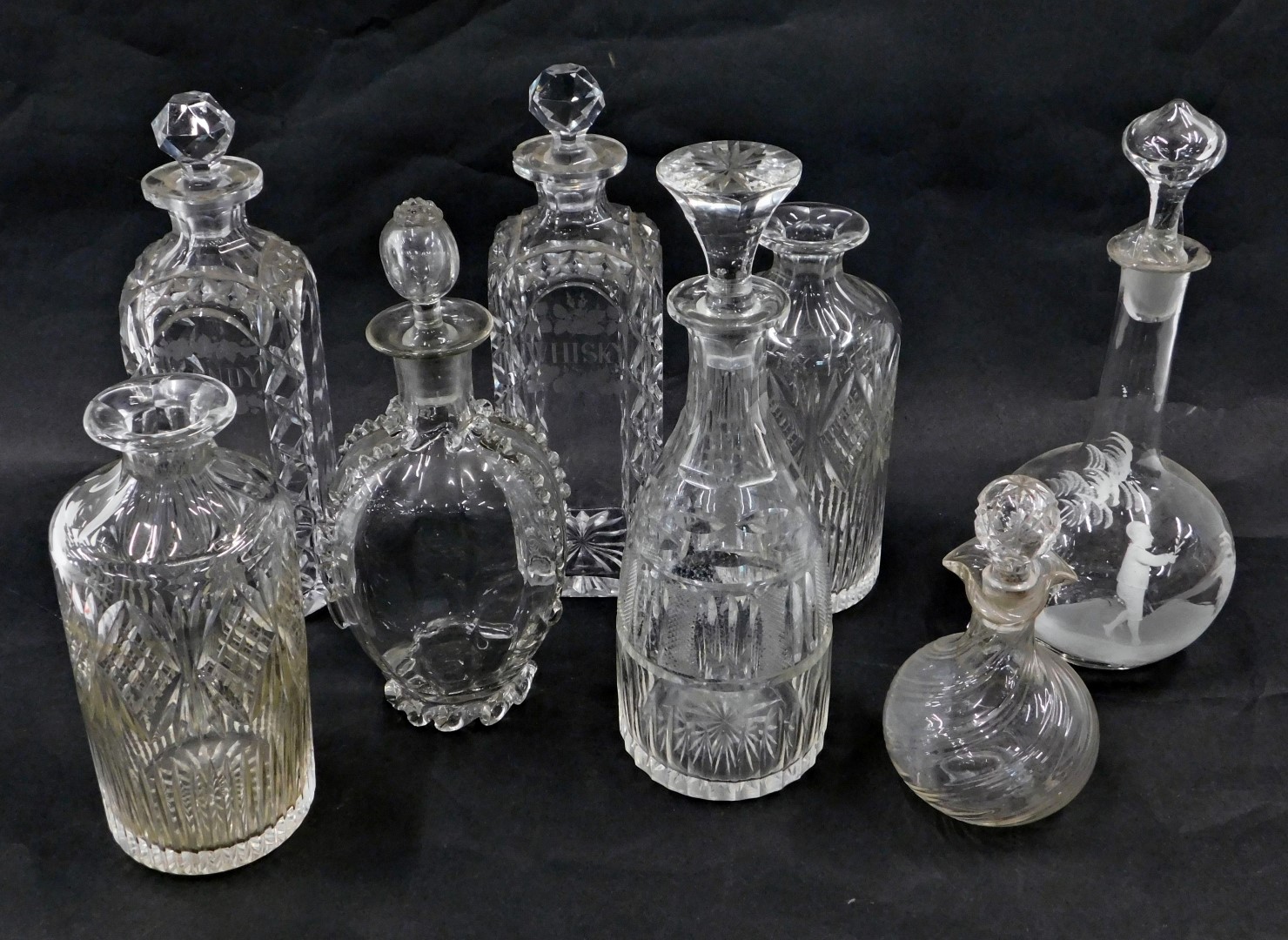A collection of 19thC and later cut glass and other decanters and stoppers. (AF)