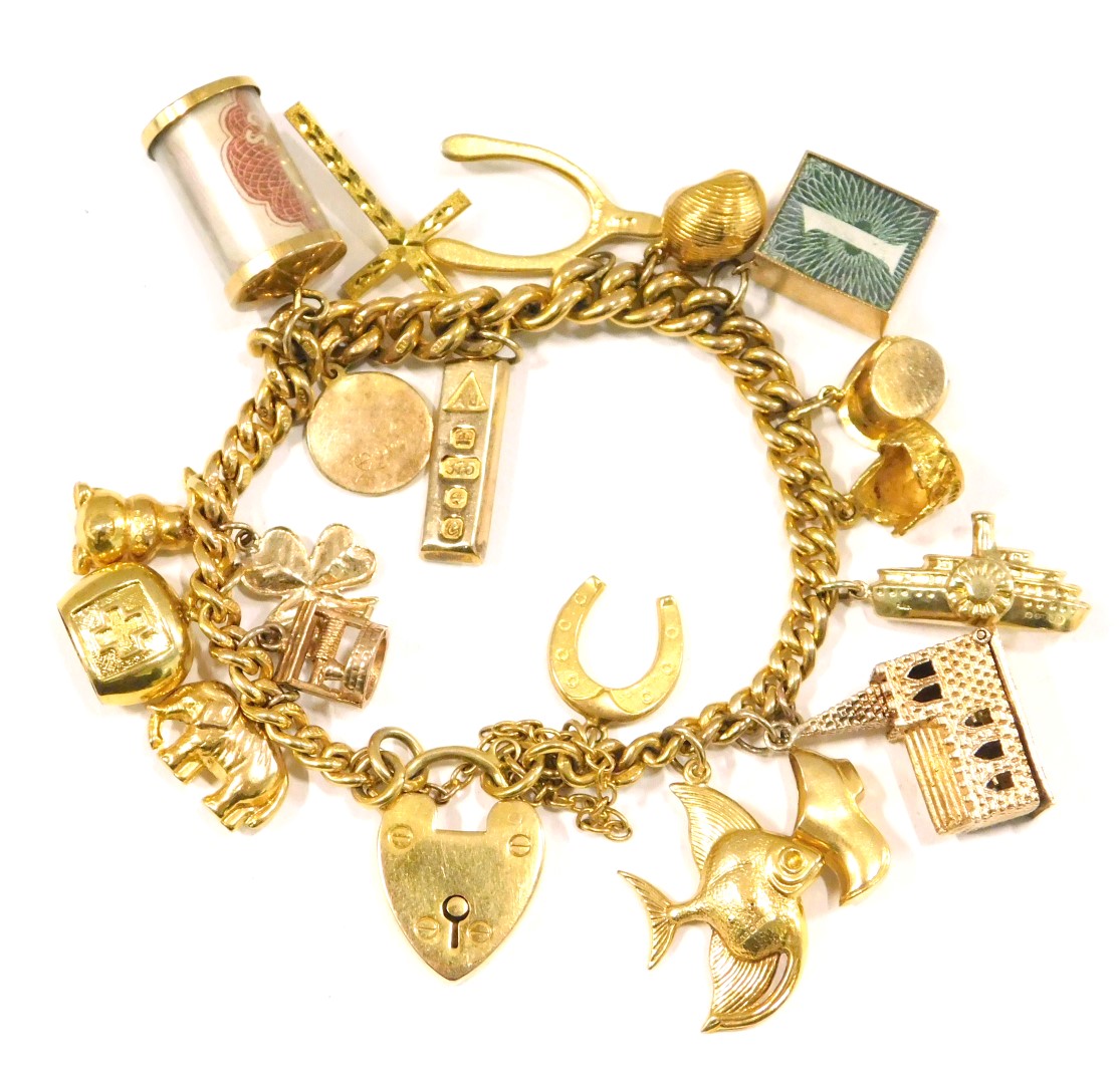 A 9ct gold charm bracelet, the curb link bracelet with safety chain and heart shaped padlock, variou