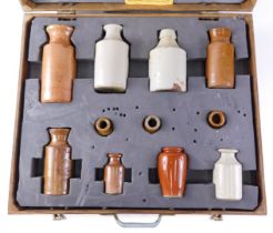 A collection of 19thC and later stoneware bottles, each brown or cream treacle glazed, in fitted ply