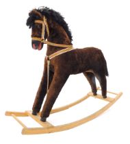 A brown plush rocking horse, with beech rockers, 107cm wide.