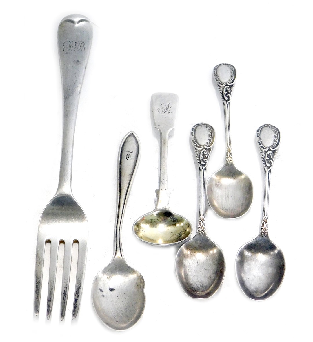 A group of silver cutlery, comprising three Edward VII silver scroll pattern teaspoons, a silver tea