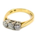 An 18ct gold three stone diamond dress ring, centrally set with princess cut diamond approximately 3