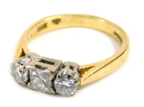 An 18ct gold three stone diamond dress ring, centrally set with princess cut diamond approximately 3