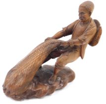 An Oriental Japanese carving of a fisherman pulling his nets, 20cm high.