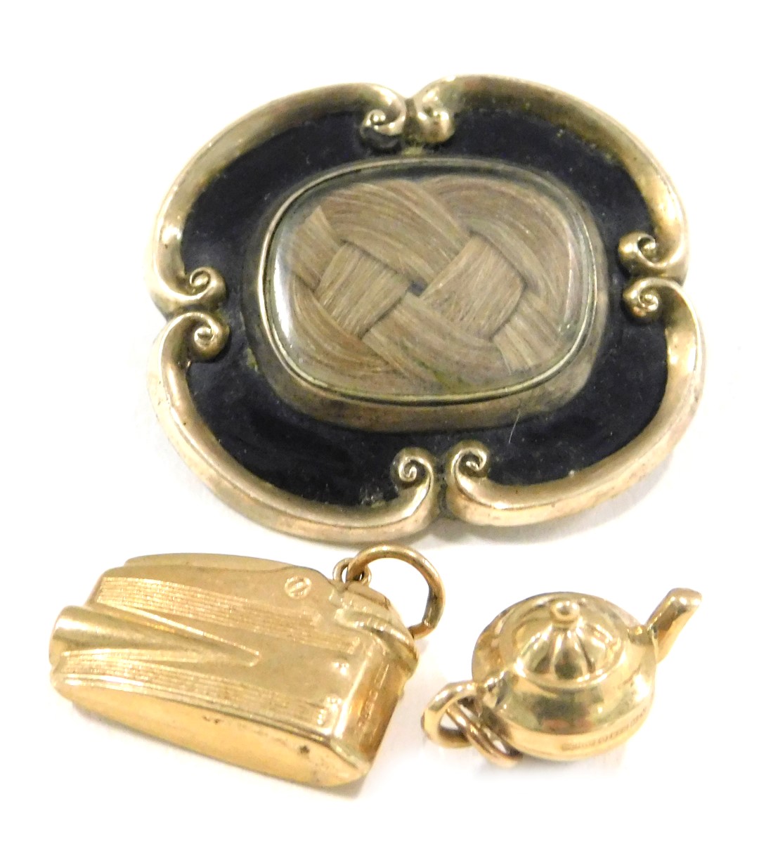 A Victorian memorial brooch and two charms, comprising a 19thC memorial brooch, in silver gilt with