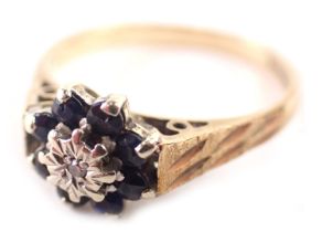 A 9ct gold floral cluster ring, set with eight point sapphire, and central CZ, with striped design s