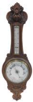 A late 19th/early 20thC aneroid barometer, in carved oak case, 90cm high.