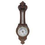 A late 19th/early 20thC aneroid barometer, in carved oak case, 90cm high.