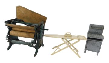 An early 20thC cast iron model of a mangle, initialled CH, a doll's house gas stove, and a metal iro