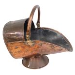A Victorian copper helmet shaped coal scuttle, with swing handle.