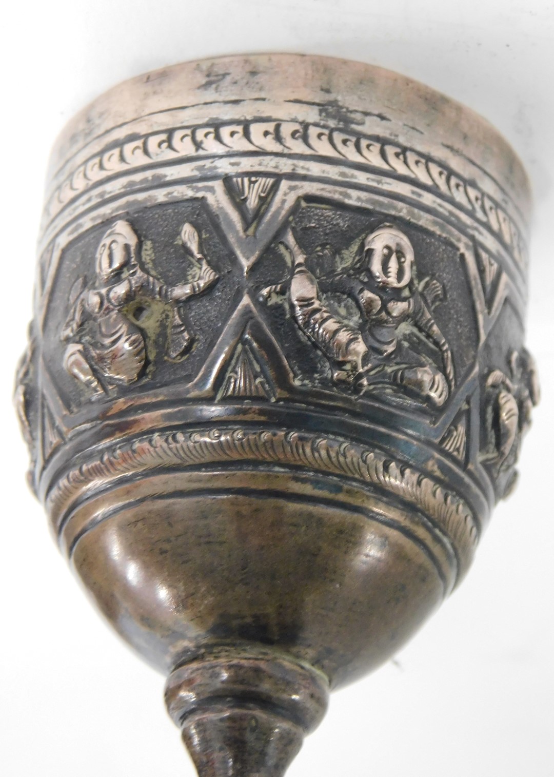 An Eastern hammered design goblet, with raised Buddhistic figures, on a hammered dot border, silver - Image 2 of 2