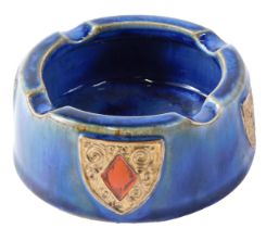 A Doulton stoneware ash tray, on a blue ground, decorated with spades, clubs, diamonds and hearts, 1