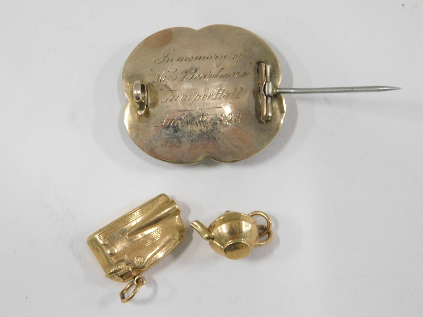 A Victorian memorial brooch and two charms, comprising a 19thC memorial brooch, in silver gilt with - Image 2 of 2