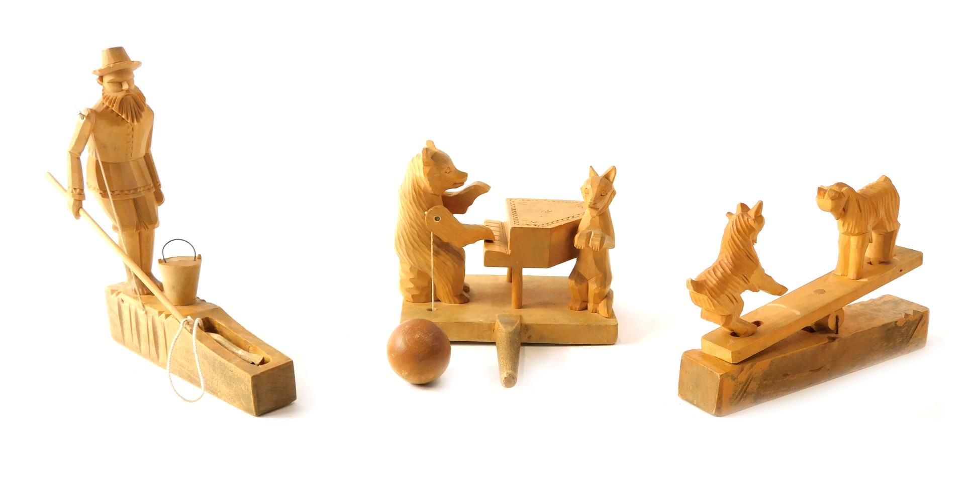 Three carved wooden animal figure groups, comprising goats on saw, man fishing, and bear playing p