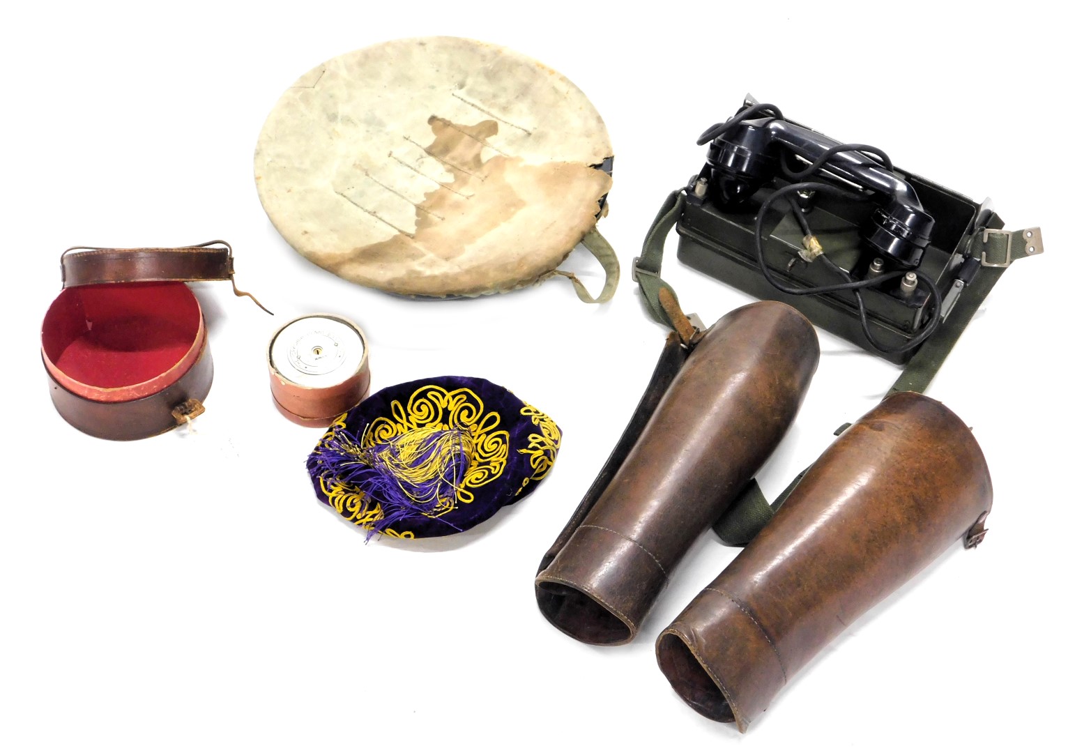 Military wares, comprising a military telephone YA7815, two leather leg cuffs, a fez, enamel bowl, a