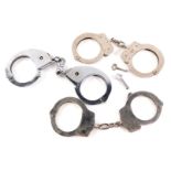 Three pairs of mainly early 20thC Haitt and other British police handcuffs.