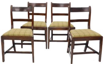 A set of four early 19thC mahogany and brass strung dining chairs, each with chequer patterned drop