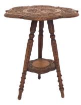 An Eastern teak occasional table, the carved top decorated with a figure holding a rifle, surrounded