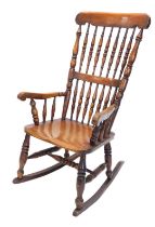 A late 19thC ash and beech spindle back rocking chair, with a solid seat, on turned legs with H stre