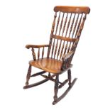 A late 19thC ash and beech spindle back rocking chair, with a solid seat, on turned legs with H stre