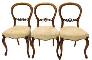 A set of three Victorian walnut balloon back chairs, each with padded seat, on cabriole legs.