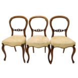 A set of three Victorian walnut balloon back chairs, each with padded seat, on cabriole legs.