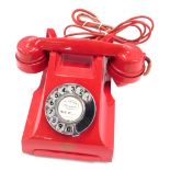 A red coloured telephone, stamped in gilt Siemens Brothers London.