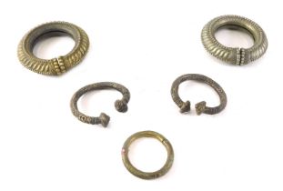 Five African silver coloured metal torcs or tribal bangles.